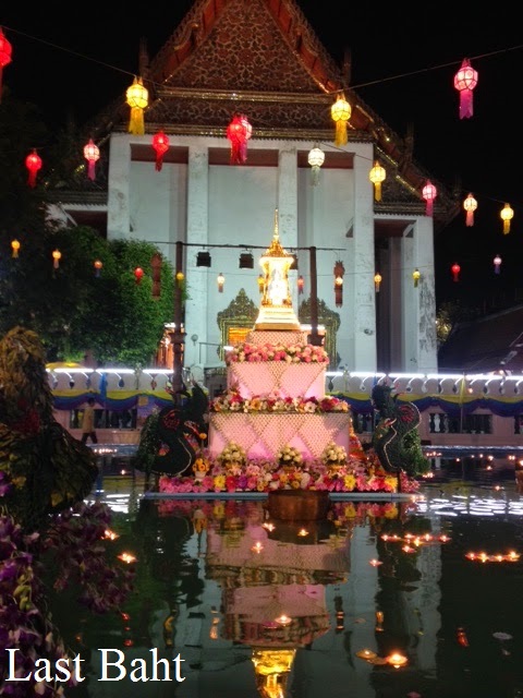 candles float on a pond outside a temple on Loi Krathong night in Bangkok